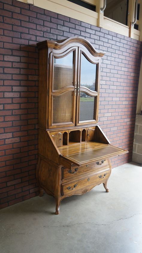 Classically French, graceful and romantic with vintage charm this Drexel Heritage secretary desk is all of this and more. The curvaceous bombe style base and top add a feminine touch. The glass doors are backed with chicken wire adding to its French provincial flair. The drop down desk has a hand tooled leather top panel and when down reveals cubbies and drawers perfect for organizing.  Item #110407-571 French Secretary Desk, Drop Down Desk, Drexel Heritage, Secretary Desks, Study Table, Hand Tooled Leather, French Provincial, Cubbies, Glass Door