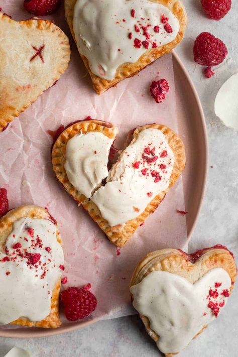 These Heart Shaped Raspberry Hand Pies make the perfect sweet treat for Valentine’s Day. Made with a flakey sweet short crust pastry and filled with fresh raspberries, raspberry jam and white chocolate, these mini pies are a delicious homemade dessert. By Emma Duckworth Bakes Raspberry Hand Pies, Chocolate Pop Tarts, Comidas Aesthetic, Lemon Meringue Tart, Romantic Desserts, Chocolate Pops, Lemon Curd Filling, Hand Pie, Freeze Dried Raspberries