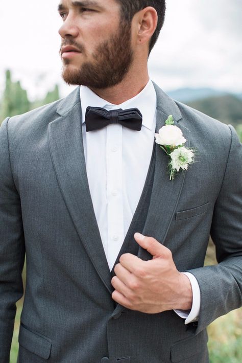 Grey suit with a matching satin bow tie for a stylish, monochromatic look. Photography: Jenny Quicksall Photography Suit With Vest Men, Blue Suit Men Wedding, Light Blue Suit Men, Black Bow Tie Wedding, Suit With Vest, Grey Tux, Gray Groomsmen Suits, Minimal Rustic, Floral Boutonniere