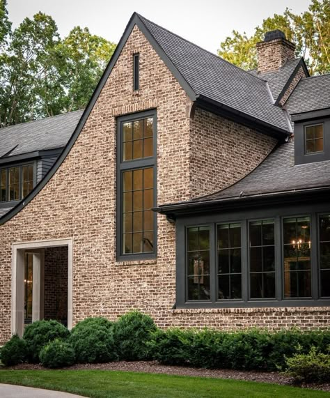 An exposed brick wall match with any home style. Like the picture above, by using exposed brick walls, it gives the exterior of the house look aesthetic. Combine it with black window trim for a more cohesive look. Exposed Brick Wall from @castlehomes #brick #brickhomeexterior #classichomeexterior #homeexterior #homeexteriormaterials #timelesshomeexterior Black House With Red Brick, Exterior House Colors With Brick Red, Black Windows Brick House, Copper Porch Roof, Light Brown Brick House Exterior, Dark Exterior House Colors With Brick, Dark Gray Brick House Exterior, Brick And Stone Home Exterior, Dark Brown Siding Exterior