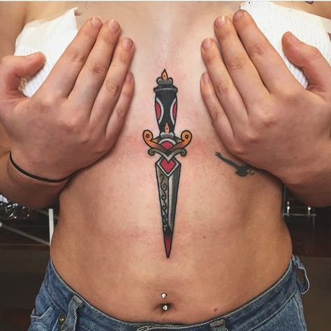 Traditional dagger tattoo inked on the sternum and belly Sternum Traditional Tattoo, Traditional Tattoo Sternum, Sternum Tattoo Dagger, Dagger In Heart Tattoo, Dagger Sternum Tattoo Women, Sternum Tattoo American Traditional, Trad Dagger Tattoo, Dagger Tattoo Sternum, Underboob Tattoo Traditional