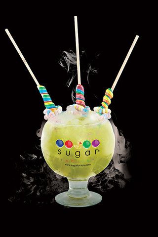 At Miami’s Sugar Factory, a brasserie and candy shop rolled into one, the 60-oz tropical drink (with a price tag of $39) is made with a mix of Midori melon liqueur, Bacardi rock coconut rum, Ketel Citroen vodka, pineapple juice and sour mix topped off with Sprite, and garnished with two unicorn lollipops and a candy necklace. Oh, and it's also presented in a cloud of dry ice. Click to see more over-the-top cocktails. Sugar Factory Drinks, Sugar Factory Las Vegas, The Sugar Factory, Las Vegas Dining, Candy Cocktails, Sugar Factory, Top Cocktails, Sweet Cocktails, Cocktail Garnish