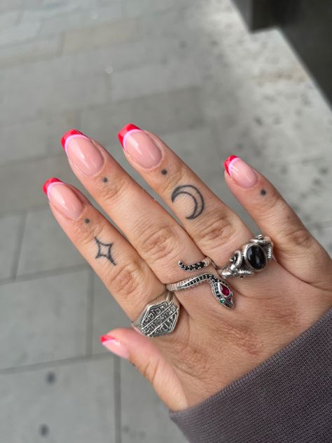 Small finger tattoos, finger tattoo dots, silver rings, pink and red nails Cuticle Dot Tattoo, Finger Tattoos Edgy, N Finger Tattoo, Sagittarius Tattoo Finger, Starburst Finger Tattoo, Finger Tattoo Traditional, Tattoo Dots On Fingers, Red Tattoo Finger, Small Toe Tattoos