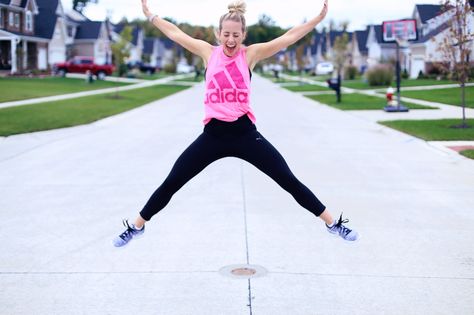 Jumping in the air in a star shape, a woman in sports clothes opens her mouth wide. Doing jumping jacks helps her stay in shape. Twist Me Pretty. Shape Workout, Thursday Workout, Star Jump, Star Jumps, Sports Clothes, Jumping Jacks, Stay In Shape, Staying In, Star Shape