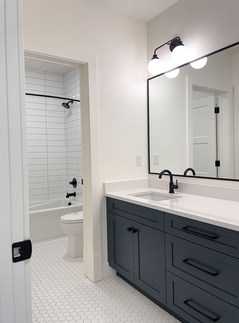 Black Hexagon Tile Bathroom White Vanity, White Bathroom With Dark Cabinets, Black And White Bathroom With Colored Vanity, Black And White Bathroom With Wood Floor, Black Hardware In Bathroom, Navy Kids Bathroom, Charcoal Vanity Bathroom Ideas, Black Appliance Bathroom, Modern Bathroom Hexagon Tile