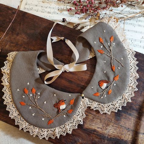 Handcrafted linen collar, mink-coloured ornate collar with robin bird hand-embroidered artistic and earth-toned flowers.  I hand-embroidered this unique bohemian clothing accessory with a cute robin bird and orange flowers inspired by nature, with 100% cotton threads.  This stylish collar is extremely durable, wear-resistant and long-lasting thanks to its high-quality fabric. It has a standard size and you can easily adjust it to fit your neck thanks to its tie at the back.  This will be the perfect and most amazing gift for your friends and family. Thanks to its dreamy, classic design, you or your loved ones can wear it daily or on special occasions! I handcraft all of my products in my workshop using only high-quality & recyclable materials. All of my products eco-friendly because I supp Cute Collars, Color Vison, Bohemian Wear, Sewing Collars, Mink Colour, Different Types Of Flowers, Bib Collar, Robin Bird, Bohemian Clothing