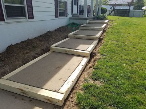 Building a side walk, building a walk on a slope, DIY sidewalk, using salvaged items to frame a walk. Sidewalk On A Slope, Diy Side Walk Walkways, Pallet Decks, Diy Sidewalk, Side Walkway, Sidewalk Landscaping, Landscape Stairs, Concrete Path, Landscape Steps