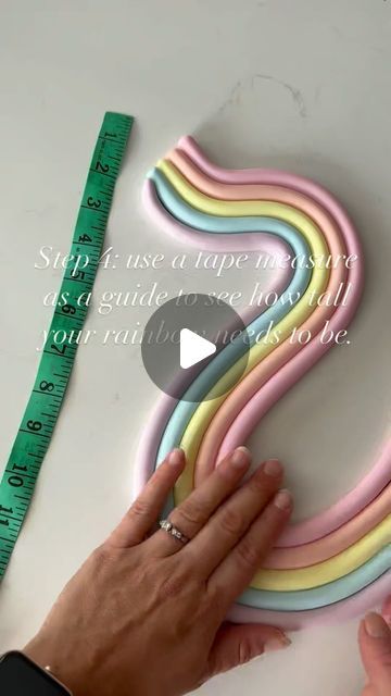 Claire Lawrence Cake Design on Instagram: "A quick video on the making of my wavy rainbows 🌈 
Here a few extra tips for you: 

-For simple shapes like rainbows I prefer to use normal fondant mixed with Tylo powder rather than modelling paste. You do have to be fairly quick with this method though because it can dry out quickly and make it difficult to roll out perfectly. 

- use an acrylic smoother not only to achieve a smooth finish but to also help make sure each colour is the same size. 

- I knew my cake would be approximately 8” tall, but I wanted it to come up towards the top tier so I shaped it to be a bit taller than that. 

- the candy melts help to solidify the rainbow which helps so much with transportation. I also added a couple of splodges of candy melts on the back and attac Simple Fondant Cake Design, Rainbow Shaped Cake, Rainbow Baby Shower Cake, Rainbow Cake Decoration, Pastel Rainbow Aesthetic, Pastel Rainbow Party, Rainbow Baking, Fondant Rainbow, Pastel Rainbow Cake