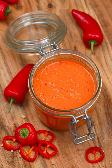 Homemade Red chilli sauce in a jar with some chilies around it Chili Sauce Recipe Canning, Homemade Chili Sauce, Homemade Chilli, Chili Pepper Recipes, Sauce Pesto, Pepper Sauce Recipe, Chili Sauce Recipe, Red Chili Sauce, Hot Chili Sauce