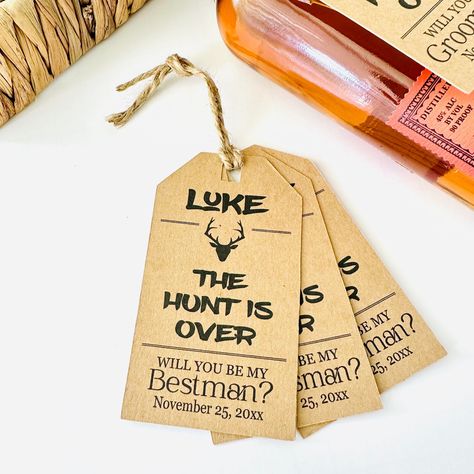 "Groomsmen proposals are all the rage and these custom \"the hunt is over with deer antlers tags are perfect for asking your best man, groomsman, ushers and officiant to stand with you on your wedding day! The beauty of this tag is it will fit just about any size bottle 187ml or larger and would look great in your proposal box.  (Tag only provided unless twine is purchased also). >>  RUSH MY ORDER ADD ON FEE - FOLLOW LINK BELOW FOR INSTRUCTIONS<<       https://www.etsy.com/listing/743684405/rush-my-order-service-fee? WHAT YOU WILL RECEIVE   Quantity: Selection made by customer Approximately 4.23\" x 2.41\" inches - rectangle shape tag ✦ ✦TWINE - 10\" of Premium Pre-Cut Black/White Twine per tag IF purchased with tags✦ ✦ PERSONALIZATION Provide the bride, groom, groomsmen, best man and ushe Groomsmen Proposal Western, Groomsmen Proposal Fishing Theme, Groomsmen Proposal Hunting, Alcohol Groomsmen Proposal, Officiant Proposal Ideas, Groomsmen Proposal Bourbon, Usher Proposal, Groomsmen Proposals, Groomsman Proposal Box