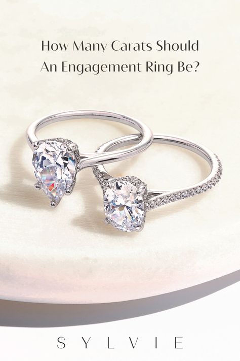 One of the most significant decisions in selecting an engagement ring is the carat size. The ideal carat size depends on personal preference, budget, and style. While 1-carat or 1.5-carat rings can give a more understated and delicate look, 2, 3 and 4-carat diamonds can provide a luxurious and wealthy look. Ultimately, the ideal carat size for an engagement ring is a personal decision that depends on several factors. Read our blog to find out more! How Many Carats Should an Engagement Ring Be? Classic Ring With Vs Clarity, White Vs Clarity Rings For Proposal, White Gold Diamond Ring With Vs Clarity For Proposal, Buying Engagement Ring Tips, Classic Diamond Ring Vs Clarity For Proposal, Unique Gold Engagement Rings, Sylvie Engagement Rings, 5 Carat Ring, Timeless Engagement Ring