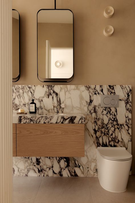 Marble ensuite vanity. Powder Room Architectural Digest, Bathroom With Mirror Wall, Mirror Over Vanity And Toilet, Transitional Primary Bathroom Design, Contemporary Classic Bathroom, Quiet Luxury Bathroom, Vanity Next To Toilet, Powder Room Makeover Inspiration, Bold Powder Room Ideas