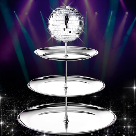 PRICES MAY VARY. Disco Theme Design: featuring an enchanting disco theme, this 3 tier silver cake stand is an intricate piece that immediately appeals and provides a fun and dazzling focus point; The charming disco ball, with its glass material, elevating the overall aesthetic appeal making it a hit at most parties or events Ideal Size and 3 Tiered Structure: sized properly at a height of about 16 inches with 3 varying tray diameters of about 10 inches, 9 inches and 8 inches respectively, the 3 Disco Ball Centerpiece, Metal Cupcake Stand, Dessert Tower, Disco Ball Decorations, 70s Disco Party, Disco Birthday Party, Disco Decorations, Disco Party Decorations, 1970s Disco