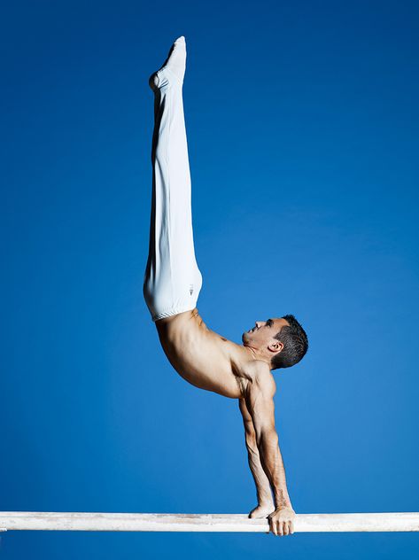 Hamilton Sabot wearing white ling trousers, doing gymnastics on white parallel bars with a ocean blue background Gymnast Reference, Ocean Blue Background, Pose Drawing Reference, Athlete Photography, Gymnastics Photoshoot, Portrait Celebrity, Male Gymnast, Characters To Draw, Gymnastics Photos