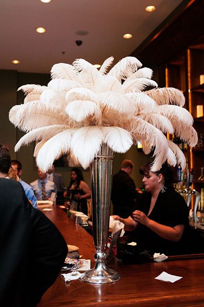 1920s Party Décor & Great Gatsby Party Ideas Guys Cooking, Art Deco Wedding Flowers, Feather Centerpiece Wedding, Roaring 20s Birthday Party, Art Deco Centerpiece, 007 Party, Deco Nouvel An, Speakeasy Wedding, Ostrich Feather Centerpieces