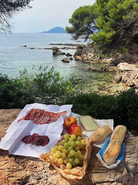 A picnic overlooks a view of the water and rocky shores South Of France Nice, Southern Europe Aesthetic, Southern France Countryside, Summer In France Aesthetic, Southern France Aesthetic, Nice France Aesthetic, French Riviera Aesthetic, South Of France Aesthetic, Summer Abroad