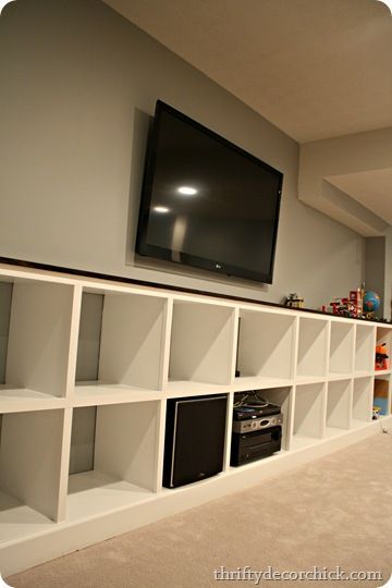 Built in cubby storage for toys and media components Built In Cube Storage, Cube Storage Built In, Cube Entertainment Center, Cubby Storage Ideas, Green Basement, Safari Playroom, Built In Cubby, Underground Lair, Built In Cubbies