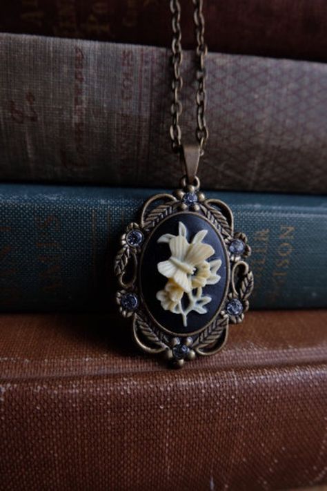 This is a sweet cameo pendant with a butterfly and flower . Has 6 rhinestones. Antiqued brass 45x30mm hangs 50mm Necklace: 24 inches long - antique brass Hange Aesthetic, Pendant Aesthetic, Flower Necklaces, Gothic Pendant, Butterfly And Flower, Pretty Necklace, Cameo Pendant, Funky Jewelry, Jewelry Lookbook