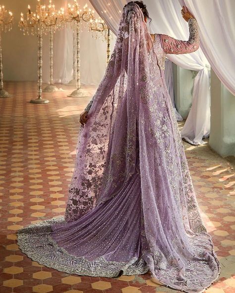 Make a luxurious statement on your special day with a masterpiece of opulence. This ensemble is lavishly adorned with intricate floral jaal patterns, heavily embellished with precision and care, and features intricately embroidered borders and a stunning neckline. Paired with a silver brocade sharara, finished with a beautiful floral border, and a lilac dupatta that shines with sequins and booti spray, this look is truly regal. The dupatta's borders are further embellished with handcrafted fl... Bridal Sharara, Sharara Dress, Pakistani Dresses Party, Pakistan Bridal, Engagement Dress For Bride, Pakistani Bridal Dress, Walima Dress, Desi Wedding Dresses, Nikkah Dress