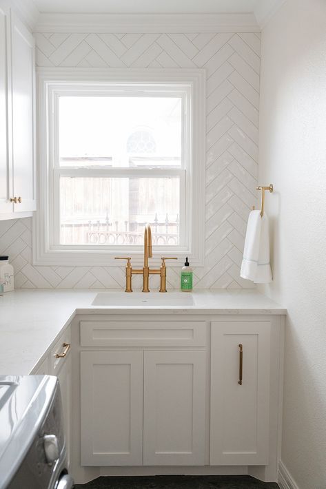 This new traditional laundry room got a fresh and clean upgrade - glossy white subway tile! We love how the herringbone pattern brings interest to the otherwise sleek lines in this space. Updating your space in small ways can make a huge difference! Tile Backsplash Laundry Room, Hexagon Tile Laundry Room, Laundry Room Tile Backsplash, Laundry Room Tile Ideas, Laundry Backsplash, Subway Tile Laundry Room, Herringbone Subway Tile Backsplash, Laundry Room Backsplash, First Floor Remodel