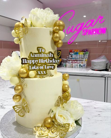 White & Gold 2 tier birthday cake, 
Super classy super girly. With choc balls, butterflies, flowers & sprinkles White 2 Tier Cake, 21st Birthday Cake White And Gold, 2 Tier Birthday Cake Butterfly, Champagne Cake Design, Birthday Cake Flowers And Butterflies, Gold Butterfly Cake, White Cake With Gold Butterflies, 2 Tier Birthday Cake, Tier Birthday Cake