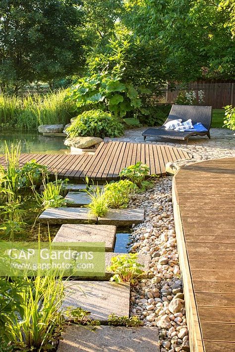 Transition zone from the pond to wooden deck with gravel, flagstones and plants including Caltha palustris, Darmera peltata, Hedera arborescens and Quercus pontica Gravel Garden With Pond, Gravel Deck, Decking Over Pond, Pond Decking, Wood Path, Trellis Fence, Arbors Trellis, Garden Pond Design, Swimming Pond