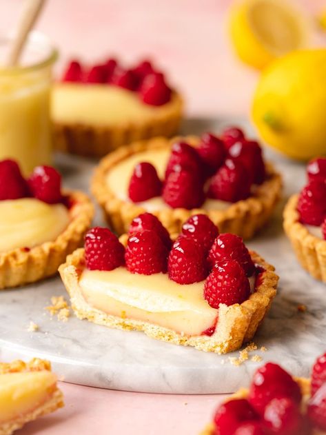 a cross-section of a mini lemon tart with glazed raspberries on top. Easy Lemon Tart, Easy Lemon Cake Recipe, Mini Lemon Tarts, Lemon Cake Mix Recipe, Lemon Tartlets, Mini Tart Recipes, Easy Tart Recipes, Lemon Yogurt Cake, Mini Fruit Tarts