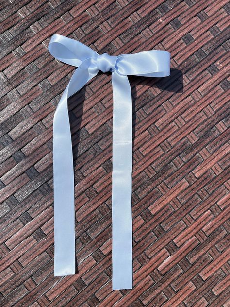 This trendy ice blue satin hair bow is the perfect anytime hair accessory and looks great in hair. Bow is made with 1-inch double-faced satin ribbon, tied by hand and secured to your choice of a 3-inch alligator clip, French barrette or ponytail holder. Bow has coordinating bloom center.  All ends are heat sealed to prevent fraying. Bow is approximately 5.5 inches in width, with 9.5-inch-long tails. Bow can be worn by girls and women. Model wearing the bow in the pictures is a teenager. Don't see the color or size you want? Just send me a message and I can set up a custom listing for you. Check out all of the beautiful colors available here:  https://www.etsy.com/shop/summergirlsbowtique/?etsrc=sdt§ion_id=47325050 Thanks so much for looking! Follow me on: Instagram: www.instagram.com/summe Satin Hair Bow, Bows Coquette, School Hair Bows, Light Blue Ribbon, Light Blue Hair, Hair Ribbon, French Barrette, Diy Ribbon, Ponytail Holder