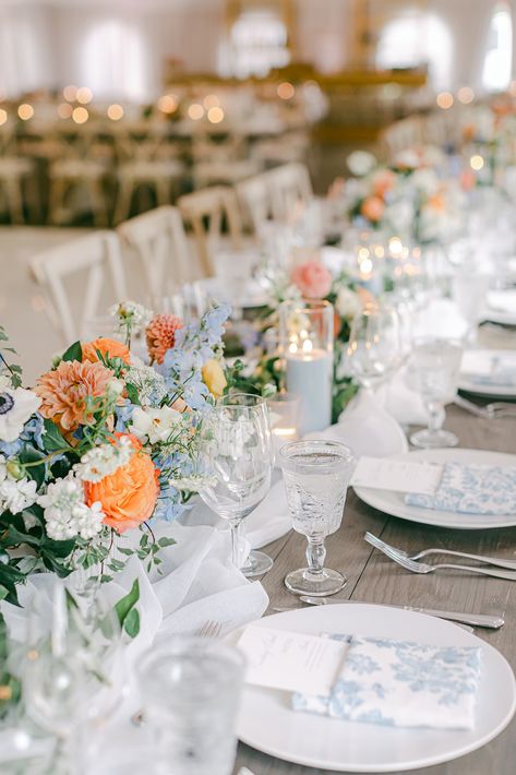 These peachy blue flower arrangements are 🙌 and those napkins? Hello! Don't forget to save and share this post for inspiration! 😘 Peach And Blue Wedding Decorations, Cornflower Blue Wedding Palette, Dusty Blue And Orange Wedding Theme, Light Blue And Coral Wedding, Blue And Orange Wedding Flowers, Dusty Blue And Peach Wedding Theme, Dusty Blue And Orange Wedding, Terracotta And Blue Wedding, Blue And Orange Wedding Theme