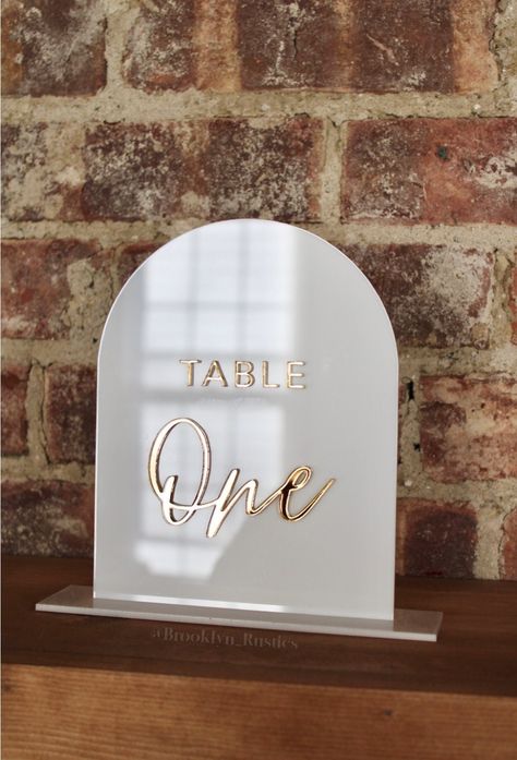 "Acrylic Table Numbers with stand, Arch Acrylic Table Numbers DISCLAIMER: Please use a dry, clean cloth to wipe down your sign/s. This item includes 1: - Arch 1/8 acrylic sign with 1/8 in acrylic letters. - 1/8 in thick stand/base (matching color base)  DIMENSIONS: - 5.5 in wide x 7 in tall - 6.5\" wide x 1.75\" base MATERIALS: - Acrylic If you would like additional signs for menu, gifts and cards, bar menu, drink stirrers, acrylic place cards etc we would be happy to create these for you. Price Boho Table Numbers Wedding, Table Number Acrylic, Acrylic Table Signs, Arched Table, Menu Drink, Acrylic Place Cards, Arch Table, Wedding Reception Hall, Acrylic Table Numbers