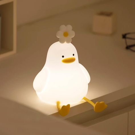 Overview Illuminate your evenings with a touch of charm and warmth using our Charming Duck Night Light with Flower. Perfect for any room, this adorable, duck-shaped silicone lamp brings a comforting glow that's ideal for both kids and adults. Its gentle light and cute design make it not just a lamp, but a delightful part of your home decor. Key Features High-Quality Material: Crafted from soft silicone, this lamp is free from sharp edges, making it safe for all ages. USB Rechargeable: Easily charge this night light with its USB charging capability. Portable: Lightweight and easy to carry, it moves seamlessly with you, providing a dependable light source wherever you go. Dual-Purpose: Ideal for both adults and children, it serves as a soothing bedside companion or a gentle night guide. Perf Duck Night Light, Cute Lamps For Bedrooms, Cute Lamps, Duck Lamp, Aliexpress Products, Silicone Lamp, Cute Lamp, Animal Night Light, Cute Night Lights