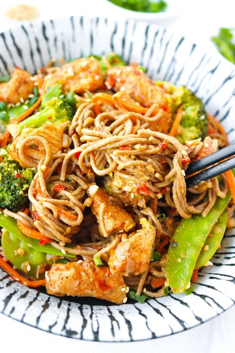 These Spicy Peanut Soba Noodles are made with fragrant aromatics, snow peas, broccoli, carrots, perfectly seasoned chicken pieces, soba noodles and a delightful creamy peanut sauce that’s spicy-sweet with a hint of tang! It’s easy to make in 30 minutes and lip-smacking tasty! #sobanoodles #noodles #highprotein #spicy #asianfood #healthy #peanutsauce #easyrecipes #highfiber #highproteinmeals #soba #stirfry #chickennoodles | That Spicy Chick Peanut Soba Noodle Recipe, Spicy Peanut Broccoli Chicken Noodles, Bjs Spicy Peanut Soba Noodles Recipe, Soba Noodles With Chicken, Pork Soba Noodles, Soba Noodles With Peanut Sauce, Chicken And Soba Noodles, Chicken Soba Noodles Stir Fry, Chicken Soba Noodles