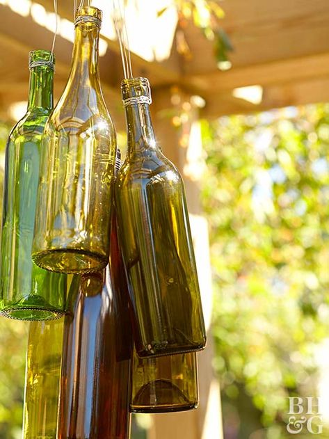 Make this adorable wind chime by wrapping empty wine bottles with aluminum wire. Hang from a pergola, overhang, or tree. #homedecordiy #diyideas #bhg Wine Bottle Chimes, Wind Chimes Ideas, Bottle Chimes, Carillons Diy, Fun Planters, Wind Chimes Homemade, Wine Bottle Wind Chimes, Outdoor Gathering Space, Colorful Planters