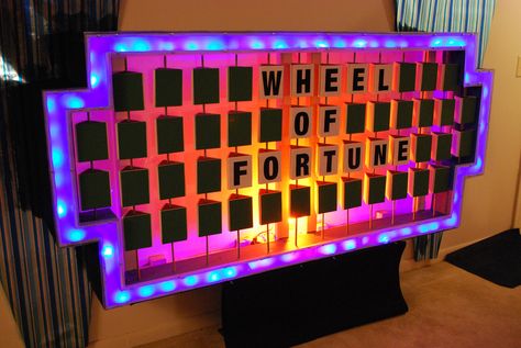 https://flic.kr/p/6dXn2s | Wheel of Fortune Puzzle Board | Here is my take on the "Wheel of Fortune" puzzle board. The frame is made of 1/2" plywood with the outside wrapped in black carpeting. The border consists of 120 blue LED lights and covered by frosted Plexiglass. The backlight is an orange CFL bulb. The trilons (letterboxes) are foamboard suspended on wooden dowel rods. 91"W x 42.5"H x 12.5"D  *Note: The height is taken from the bottom of the board not the p Frosted Plexiglass, Multi Verse, Wheel Of Fortune Game, Work Engagement, Helen Doron, Diy Yard Games, Greek Week, American Girl Doll House, Elderly Activities