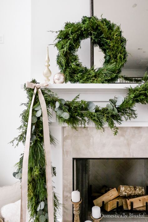 This DIY fresh evergreen garland is inexpensive to create with a mixture of foraged fresh evergreen stems and faux eucalyptus stems topped with two champaign ribbon bows. Christmas Fireplace Garland, Evergreen Garland, Fireplace Garland, Eucalyptus Stems, Diy Christmas Garland, Faux Eucalyptus, Minimal Christmas, Christmas Decor Inspiration, Christmas Tablescape