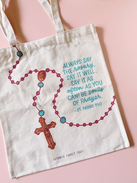 Introducing the Rosary Tote Bag from Catholic Family Crate! Carry your faith with you wherever you go with our beautifully designed Rosary Tote Bag. Perfect for all Catholics, this tote is not just a practical accessory, but a heartfelt expression of devotion and prayer. Inspiring Design Adorned with a detailed rosary design and an inspiring quote from St. Padre Pio, this tote serves as a daily reminder to embrace a life of prayer: "Always say the rosary. Say it well. Say it as often as you can! Rosary Painting, Rosary Design, Catholic Clothing, Saying The Rosary, Catholic Symbols, Recuerdos Primera Comunion Ideas, St Padre Pio, Catholic Decor, Catholic Crafts