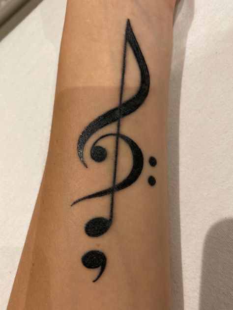 A tattoo of a treble clef combined with the bass clef so the bass clef replaces a part of the treble clef. The bottom dot of the treble clef is the upper part of a semicolon. Semi-colon Tattoo With Music Note, Hidden Semi-colon Tattoo Ideas, Therapy Tattoo, Semi Colon Tattoo, Semicolon Tattoos, Colon Tattoo, Semi Colon, Music Note Tattoo, Semicolon Tattoo