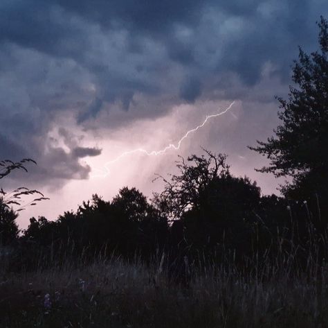 Girl with dark hair stood in a long grass feild watching the lightning in the blue clouds Stormy Skies Aesthetic, Storm Core, Stormy Aesthetic, Silhouette Aesthetic, Storm Aesthetic, Storm Watching, Storm Lightning, Field Aesthetic, Town Aesthetic