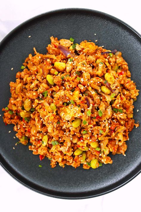 This Korean Cauliflower Fried Rice is quick and easy to make in one wok and full of BIG and BOLD flavors! Ground chicken, cauliflower rice, fragrant aromatics, scrambled eggs and veggies get tossed with spicy-smoky gochujang and other Korean-style seasonings! It’s ready in 30 minutes, high in protein, filling and DELICIOUS!  #cauliflowerfriedrice #healthy #highproteinmeals #highprotein #onewokwonder #koreanfood #asianfood #spicy #gochujang #friedrice #mealprep #dinner | That Spicy Chick Korean Cauliflower, Chicken Cauliflower Rice, Eggs And Veggies, Mealprep Dinner, Cauliflower Fried, Chicken Cauliflower, Cauliflower Fried Rice, Ground Chicken, Asian Cooking