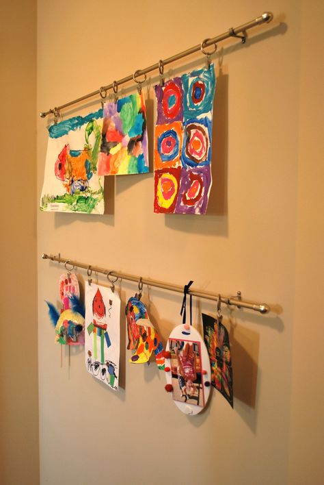 Art display using simple cafe rods with clip rings for Holiday's art gallery Hanging Art In Front Of Window, Art Rail Display, Kids Art Gallery Wall, Playroom Basement, Cafe Rod, Art Bulletin Boards, Simple Cafe, Displaying Kids Artwork, Kids Art Galleries