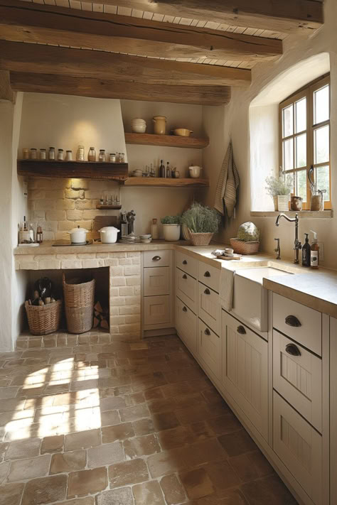 Warm, rustic kitchen with natural stone floors, wooden ceiling beams, and open shelving displaying earthenware. Cozy Rustic Home Aesthetic, Table In Small Kitchen, Quaint Kitchens, Small Farmhouse Interior, Country Small Kitchen, European Home Aesthetic, Kitchen Design Cozy, Italian Kitchen Aesthetic, Country Aesthetic Home