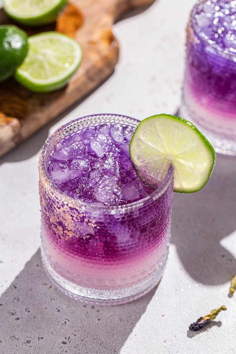 The Galaxy Margarita is as tasty as it is beautiful! Tequila that's naturally colored by butterfly pea flowers is layered on top of a Cointreau and lime base. Edible glitter takes it to the next level! It is a fun galactic spin on a classic margarita. This is the perfect margarita recipe for a girls night, bachelorette or just a night of stargazing! Ginger Shrub Recipe, Perfect Margarita Recipe, Summer Happy Hour, Pink Gin Cocktails, Classic Tequila Cocktails, The Perfect Margarita, Shrub Recipe, Butterfly Pea Flowers, Simple Syrup Cocktails