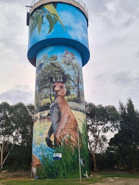 The tank was painted in April 2022 by Damian Mitchell, an artist who grew up in nearby Wagga Wagga. As a teen he moved to Prague and then spent the last 10 years working in New York. He recently moved back to Sydney with his wife. With this project, he hoped to inspire local artists while he works on a mural on Walla's water tower. It took him about a month to complete the mural on Walla's water tower, which depicts the town's settlers and animals endemic to the area. 35°45'43.4"S 146°54'09.3"E Work Overseas, Tank Art, Wagga Wagga, Work In New York, The Last 10 Years, Walla Walla, Water Tower, Australian Artists, A Teen