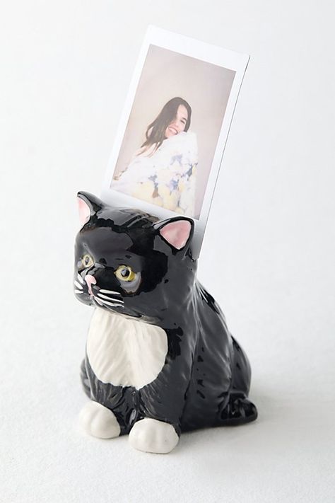 The purr-fect finishing touch to your photo displays, our Grumpy Kitty Photo Stand adds vintage charm to your INSTAX mini memories. This stoneware photo stand features an itty bitty grumpy kitty silhouette. Available exclusively at Urban Outfitters. Features Ceramic photo stand from Urban Outfitters Petite cat silhouette we love Versatile - use it to add a playful finishing touch to your shelves or accent tables UO exclusive Content + Care Stoneware Wipe clean Imported Size Dimensions: 2.25" l x 1.5" w x 2.75" h Weight: 0.13 lbs | UO Grumpy Kitty Photo Stand in Black at Urban Outfitters Cat Decorations Birthday, Urban Outfitters Gifts, Kitty Silhouette, Grumpy Kitty, Cat Room Decor, Vintage Trinkets, Cat Gift Ideas, Cat Trinket, Cat Home Decor