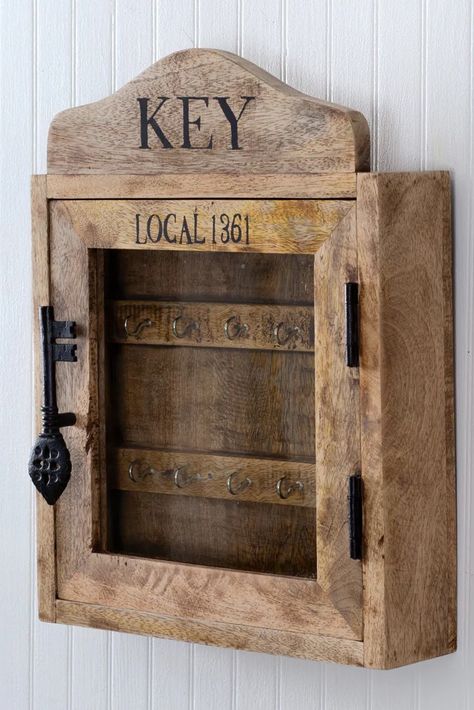 This distressed wood wall hanging key box, reminiscent of old hotel key holders, features ten interior hooks, a magnetic closing door, and a large iron key handle, perfect for keeping your family's keys organized with vintage farmhouse charm. Measures 11.75"W x 3"D x 15.25"H Made of solid mango wood Hangs using two d-hooks on the back Key Box Holder, Distressed Wood Wall, Old Hotel, Wall Mounted Key Holder, Western Artwork, Key Box, Rustic Storage, Wood Wall Hanging, Key Organizer