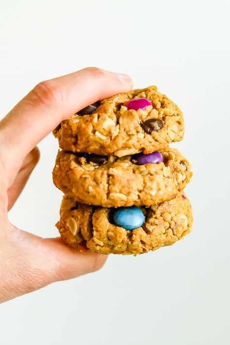 Hand holding a stack of three gluten-free peanut butter monster cookies made with oats and colored candies. Edible Desserts, Peanut Butter Monster Cookies, Gluten Free Monster Cookies, Peanut Butter And Chocolate Chips, Oats Peanut Butter, Oatmeal Peanut Butter, Monster Cookies Recipe, Healthier Treats, Eating Bird Food