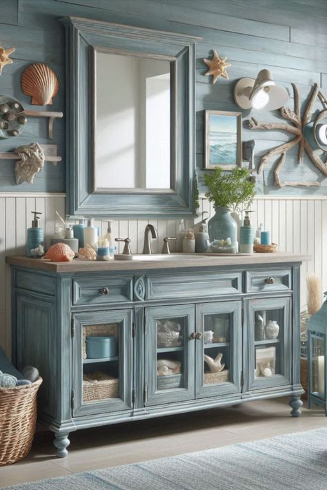 Bring beachy vibes to your bathroom with this weathered blue vanity. Perfect for a coastal-themed retreat. #CoastalDecor #BeachHouseStyle China Cabinet Bathroom, Bayou Cottage, Girl Vanity, Theme Bathroom, Girls Vanity, Blue Vanity, Ocean Girl, Beach Theme Bathroom, Cabinet Bathroom