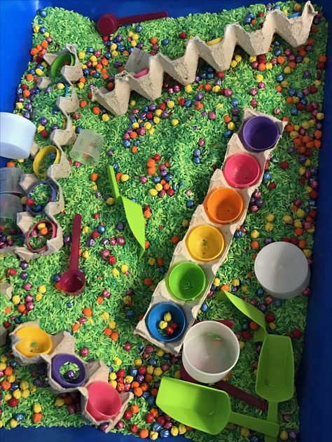 Easter sensory bin I died green rice in 2 different shades of green. Then I colored dried chick peas different colors. I added egg crates with plastic eggs hot glued in so the children color sort chick peas. I used acrylic paint to color rice and chick peas. It's a brighter color and it last longer. Easter Rice Sensory Bin, Plastic Egg Sensory Bin, Split Pea Sensory Bin, Classroom Sensory Bin Ideas, Easter Sensory Activities For Preschool, Colorful Sensory Bin, Easter Egg Sensory Bin, Spring Sensory Bin Ideas, Dry Sensory Bin Ideas