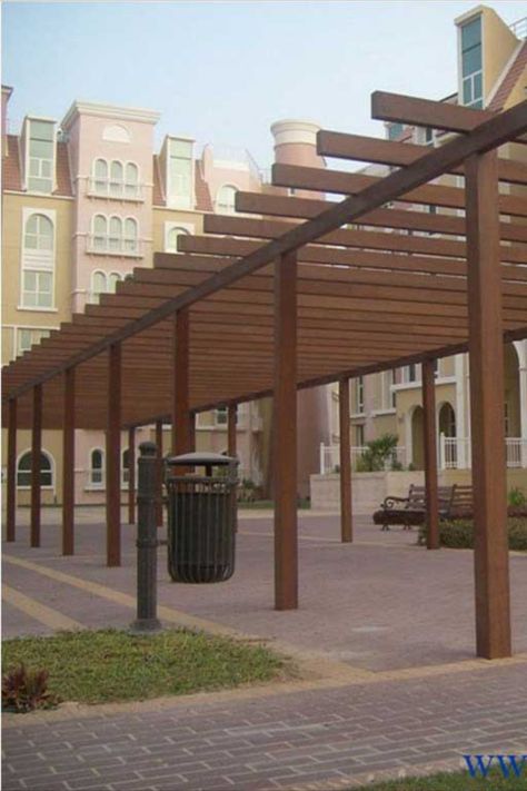 Technowood created this structure to provide a [partially shaded pathway, adding a decorative element to the urban area without detracting from the surrounding architecture. Shading Elements Architecture, Wood Shade Structure, Timber Cladding, Shade Structure, Wood Shades, Urban Area, The Urban, Pergola, Outdoor Structures