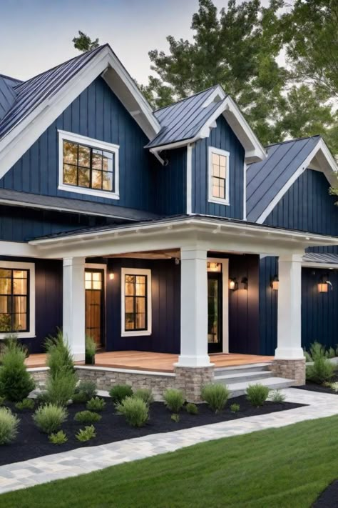 Modern blue house with white trim and a covered porch, surrounded by neatly landscaped greenery. Farmhouse House Colors Exterior, Blue Exterior Farmhouse, Modern Blue House Exterior, Farmhouse Siding, Farmhouse Cottage Exterior, Blue Home Exterior, Modern Farmhouse Exterior Colors, Country Farmhouse Exterior, Farmhouse Exterior Paint Colors